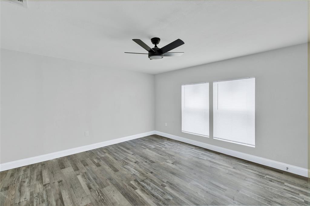 501 North Miller Street Decatur, TX 76234 - Photo 15 of 24 Wood-finish flooring, white walls, two windows with blinds, and a ceiling fan