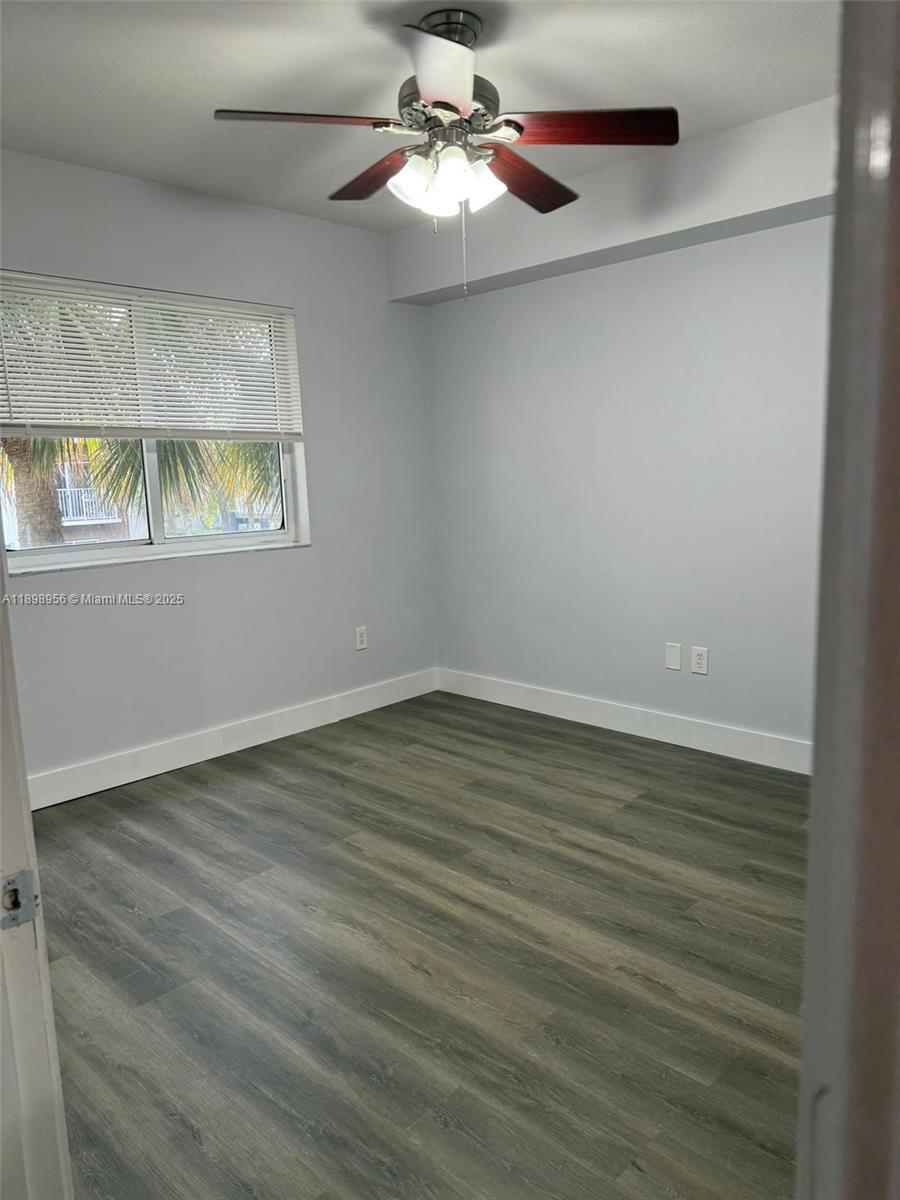 11040 Southwest 196th Street, Unit 211 Cutler Bay, FL 33157 - Photo 3 of 10 wooden floor in an empty room with a window