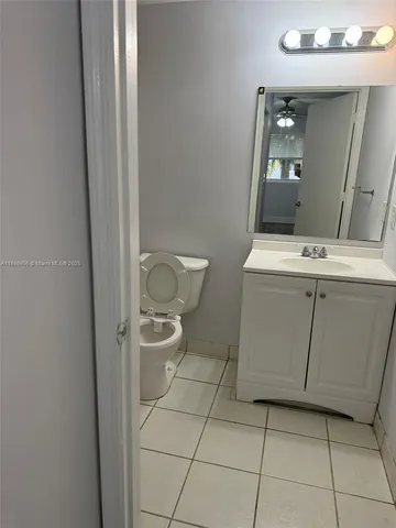 a bathroom with a toilet a sink and mirror