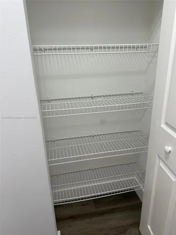 a view of staircase with white walls and white door