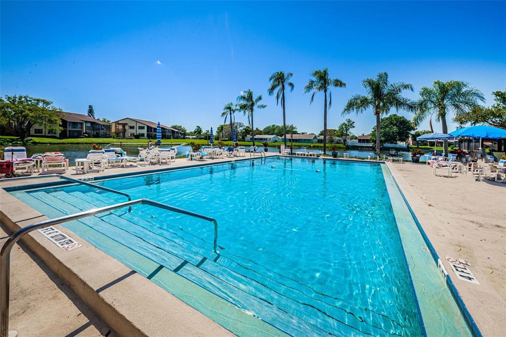 3847 Lighthouse Way, Unit 3847 New Port Richey, FL 34652 - Photo 52 of 89 a view of a swimming pool with a table and chairs