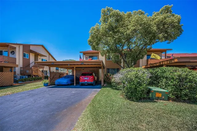 a front view of a house with a yard and a pond