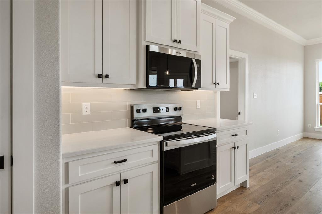 507 Limestone Circle Mabank, TX 75147 - Photo 13 of 36 a kitchen with white cabinets and black appliances