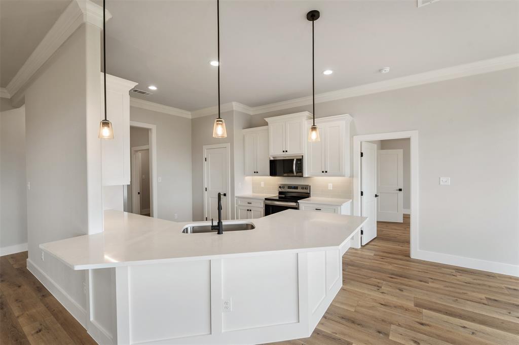 507 Limestone Circle Mabank, TX 75147 - Photo 8 of 36 a large kitchen with kitchen island a sink counter space and stainless steel appliances
