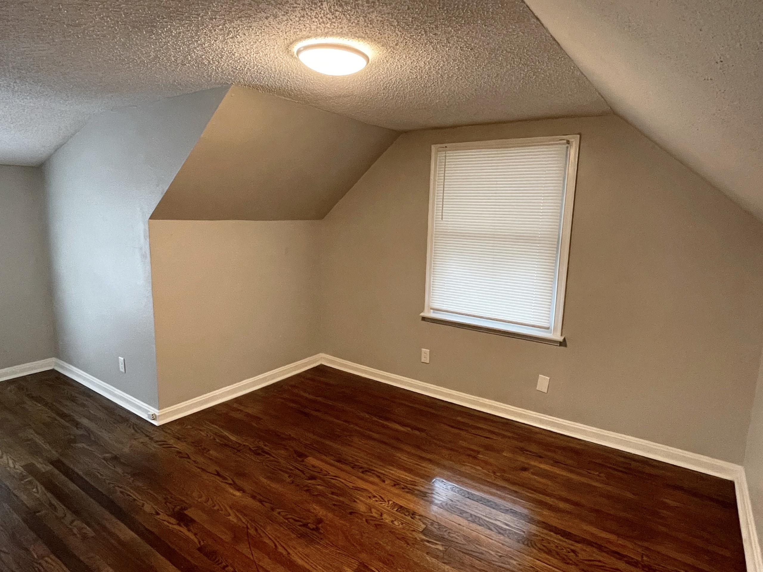 984 East Raines Road Memphis, TN 38116 - Photo 8 of 19 a view of an empty room with wooden floor and a window