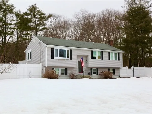 a front view of a house with a snow in the background