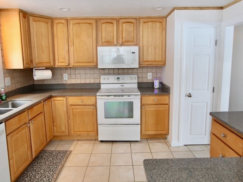 54 Ann Street Raynham, MA 02767 - Photo 4 of 21 a kitchen with a stove a sink and a refrigerator