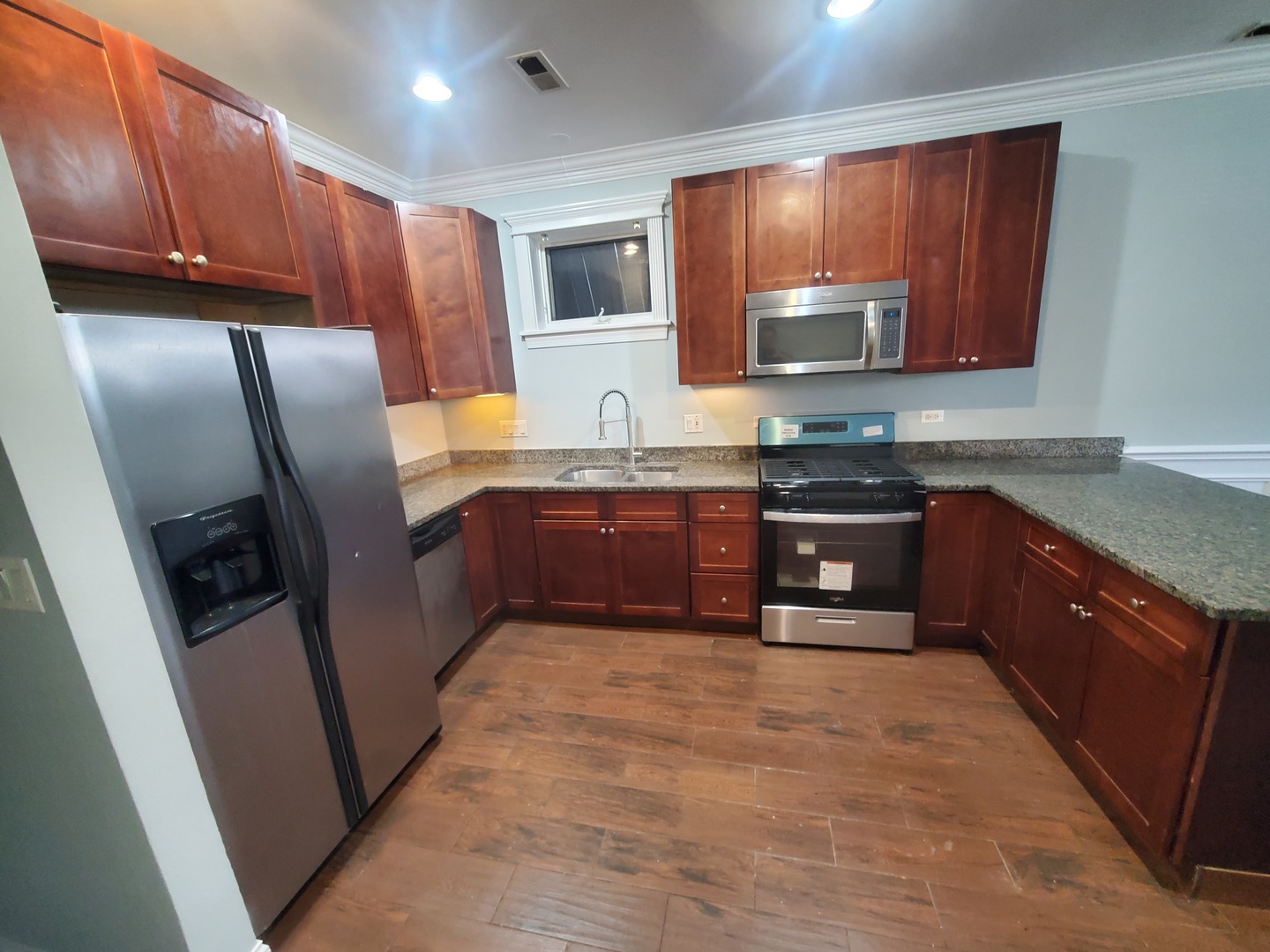 Undisclosed Address Chicago, IL 60645 - Photo 21 of 22 a kitchen with stainless steel appliances granite countertop wooden cabinets a stove top oven a sink and dishwasher