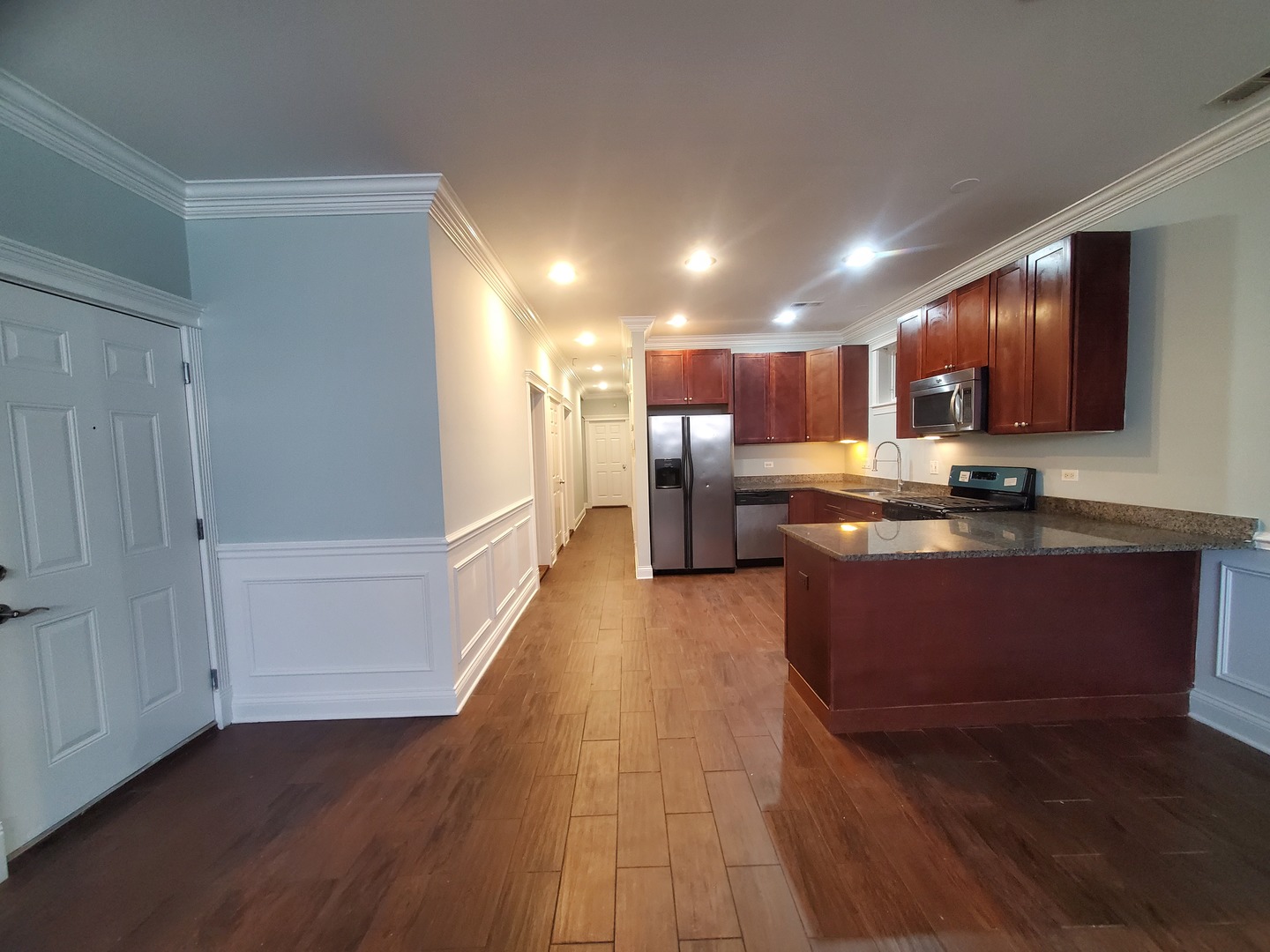 Undisclosed Address Chicago, IL 60645 - Photo 3 of 22 a kitchen with stainless steel appliances granite countertop a stove a refrigerator a sink and a oven with wooden floor
