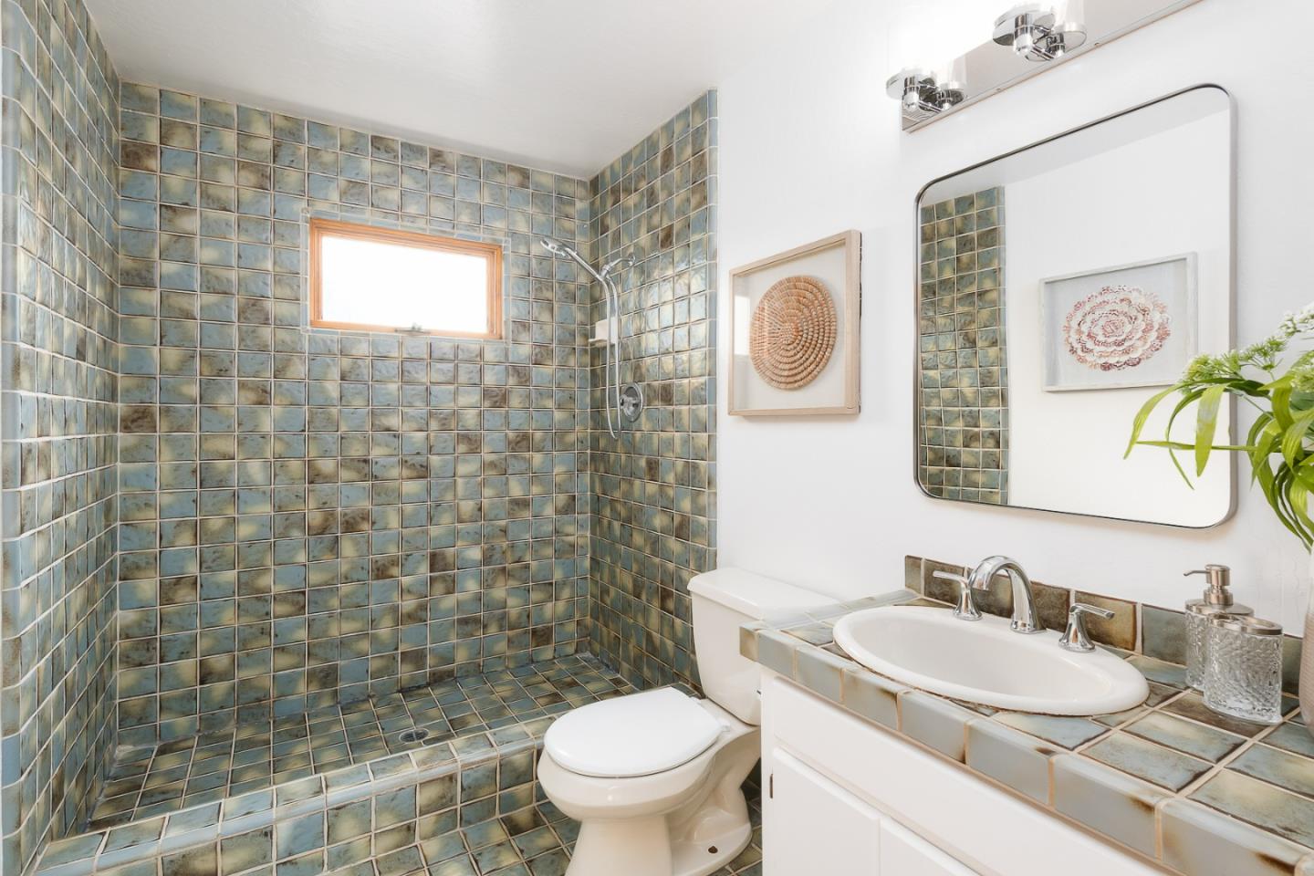 3217 Upper Lock Avenue Belmont, CA 94002 - Photo 25 of 59 a bathroom with a granite countertop toilet a sink a mirror and a shower