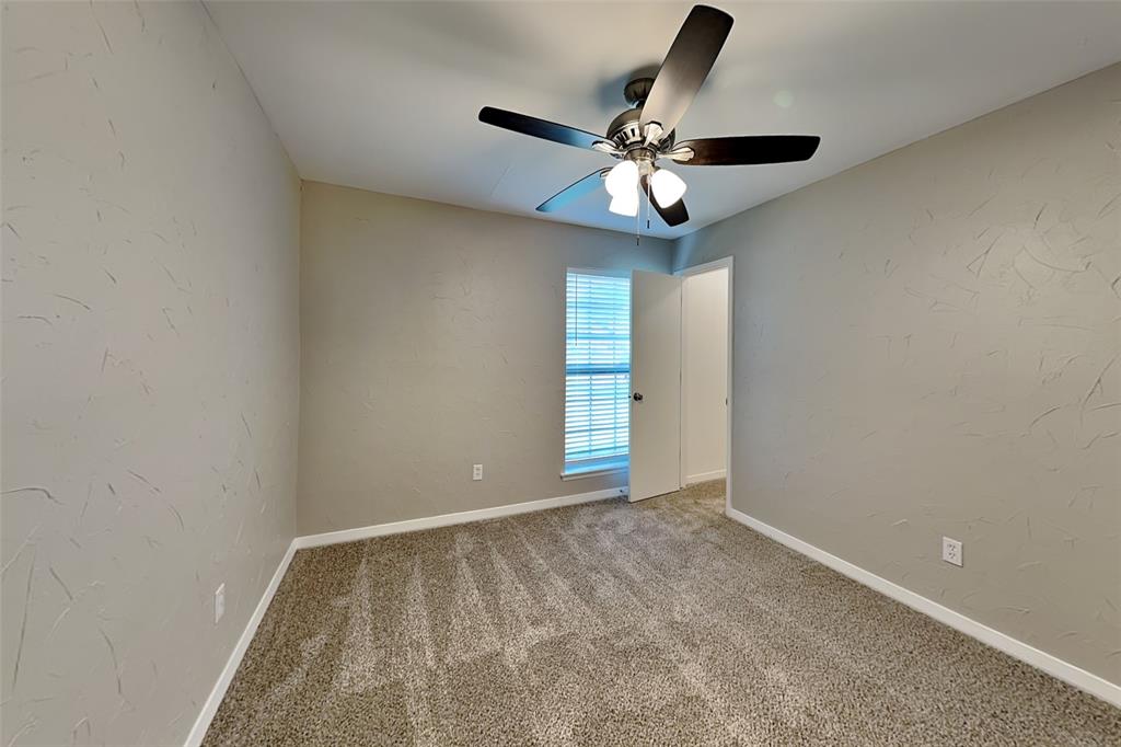 6432 Ridglea Drive Watauga, TX 76148 - Photo 13 of 18 Unfurnished room featuring a textured wall, carpet, and ceiling fan