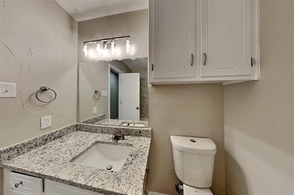6432 Ridglea Drive Watauga, TX 76148 - Photo 15 of 18 Bathroom featuring a textured wall, vanity, and a textured ceiling