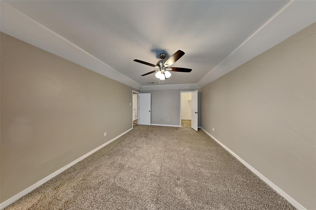 6432 Ridglea Drive Watauga, TX 76148 - Photo 9 of 18 Unfurnished bedroom featuring carpet flooring, a spacious closet, and ceiling fan