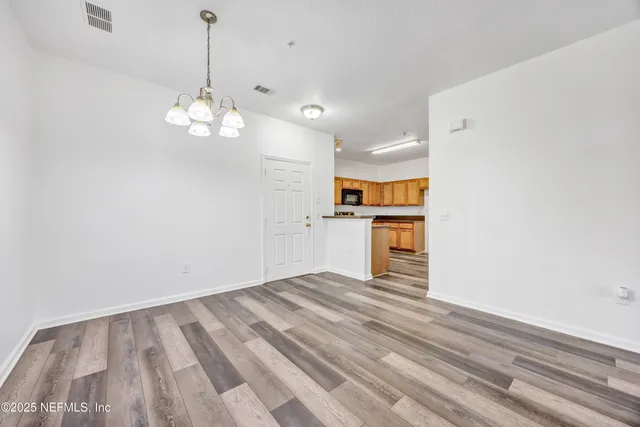 a view of a kitchen with a sink dishwasher a refrigerator with wooden floor and a window