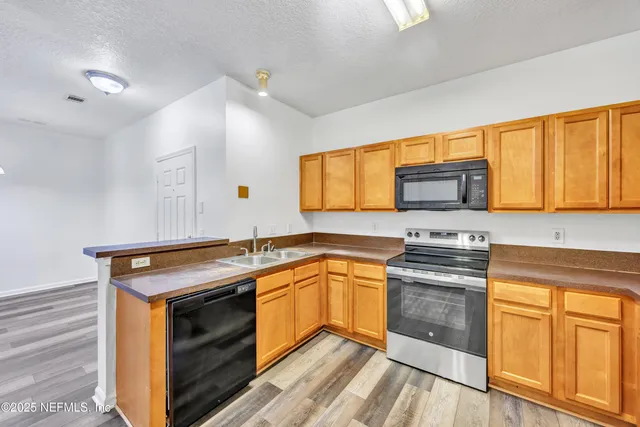 a kitchen with stainless steel appliances a stove sink and cabinets