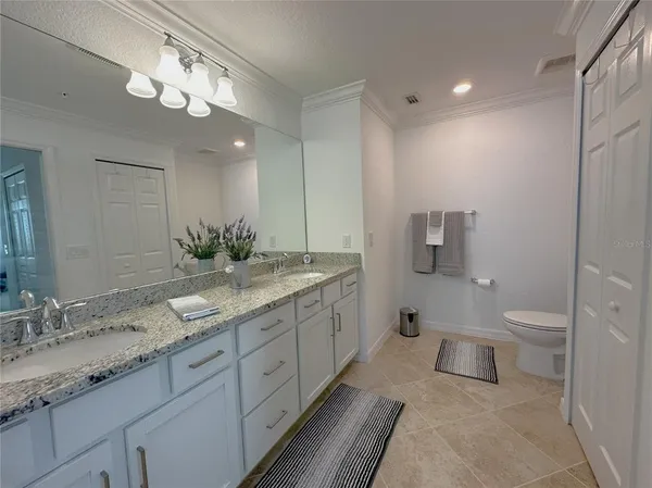 a bathroom with a granite countertop sink toilet and a mirror