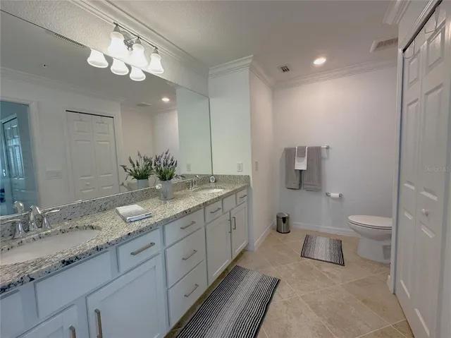 a bathroom with a granite countertop sink toilet and a mirror