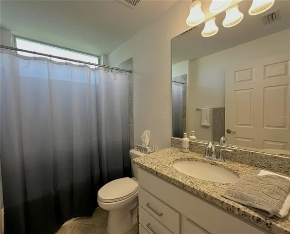 a bathroom with a toilet and a view of bathroom