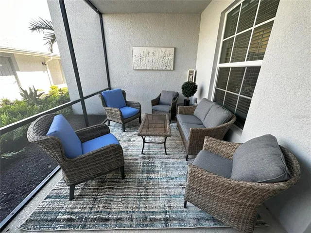 a living room with furniture tv and a floor to ceiling window