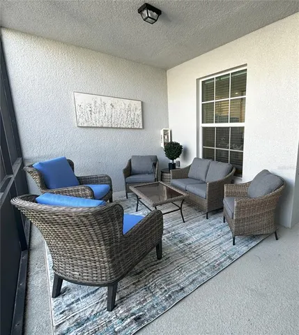 a kitchen with stainless steel appliances kitchen island granite countertop a refrigerator a stove a sink a dining table and chairs with wooden floor