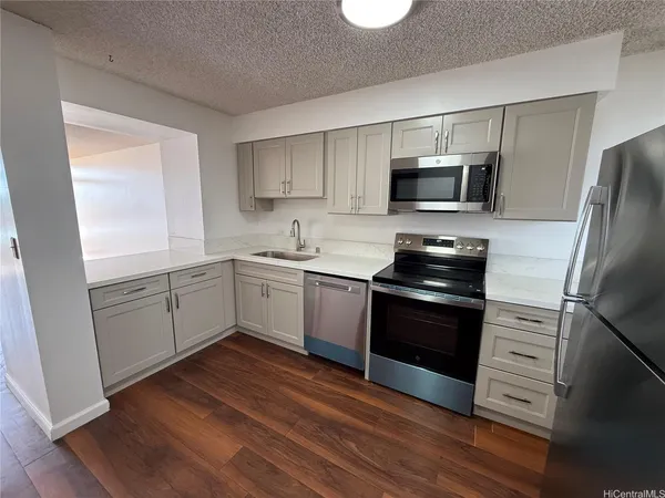 a kitchen with a sink a microwave a refrigerator and cabinets
