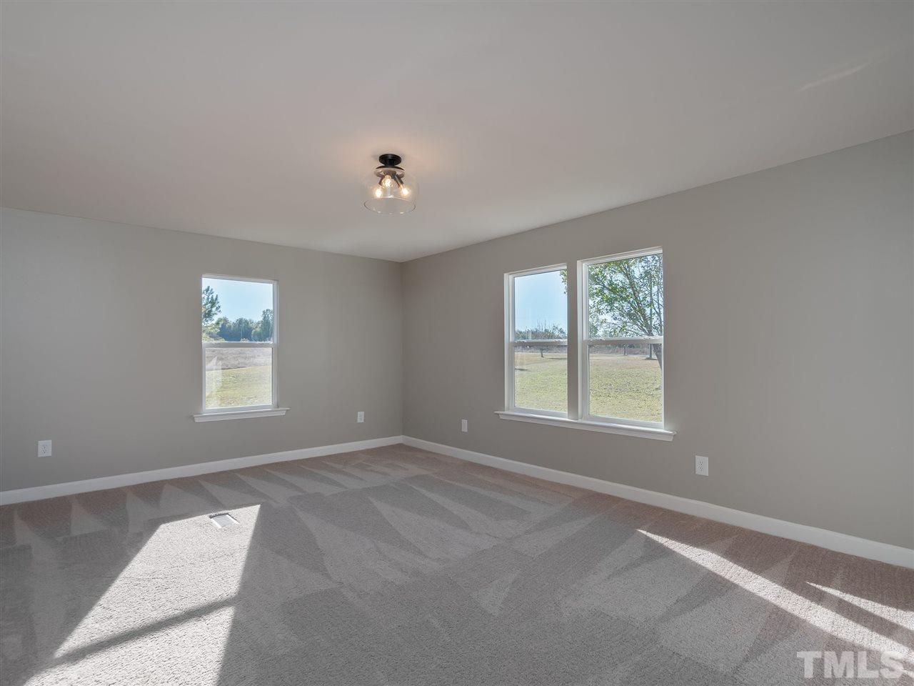 1825 Wire Road Bunnlevel, NC 28323 - Photo 12 of 30 Large, bright & airy owner's suite with new light fixtures and new carpet! Enjoy the lovely views of the estate from your bedroom.