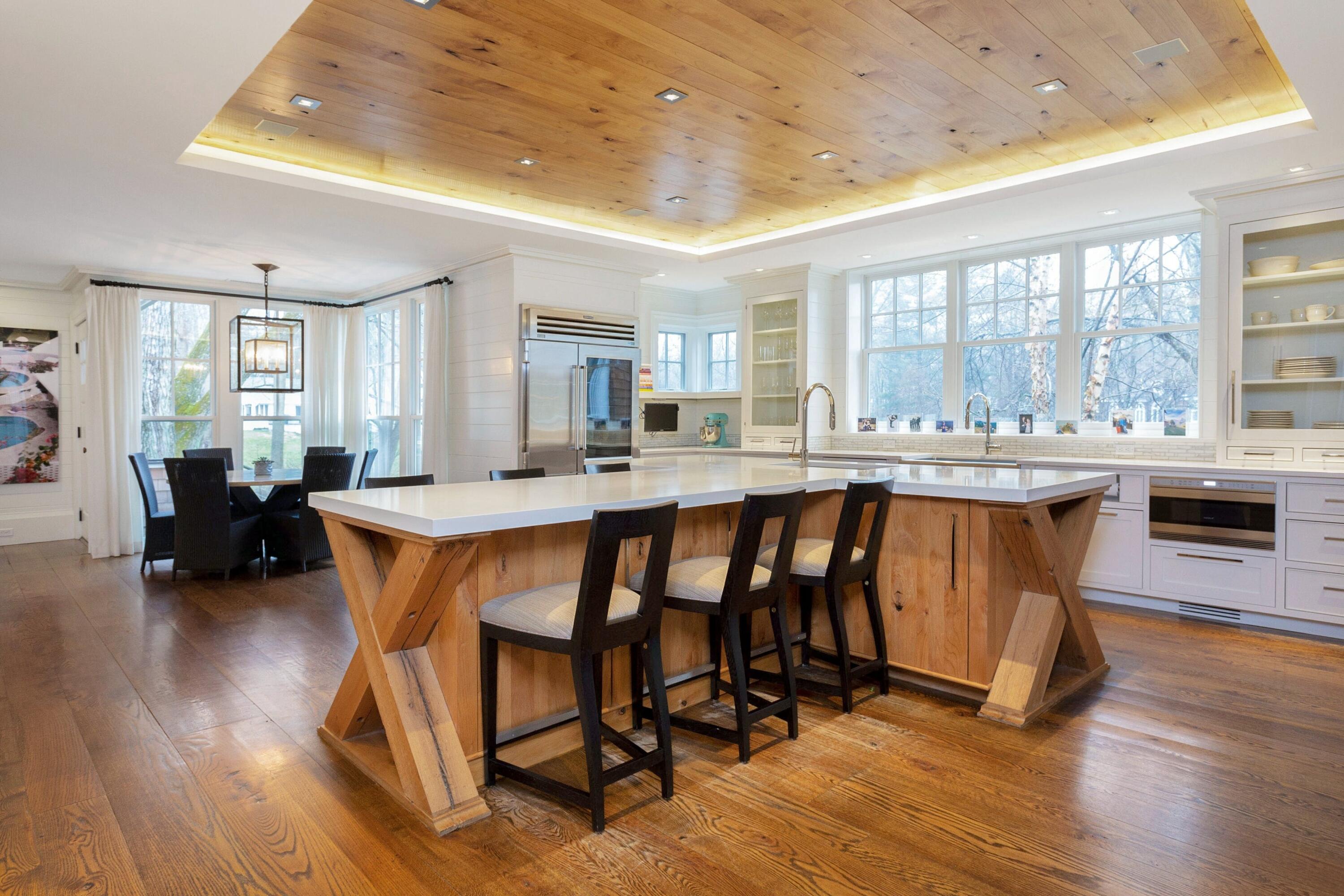 20 Driftway Lane Darien, CT 06820 - Photo 21 of 76 a dining hall with stainless steel appliances granite countertop a stove a sink a refrigerator white cabinets a dining table and chairs with wooden floor