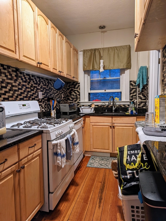 a kitchen with a stove a sink and cabinets