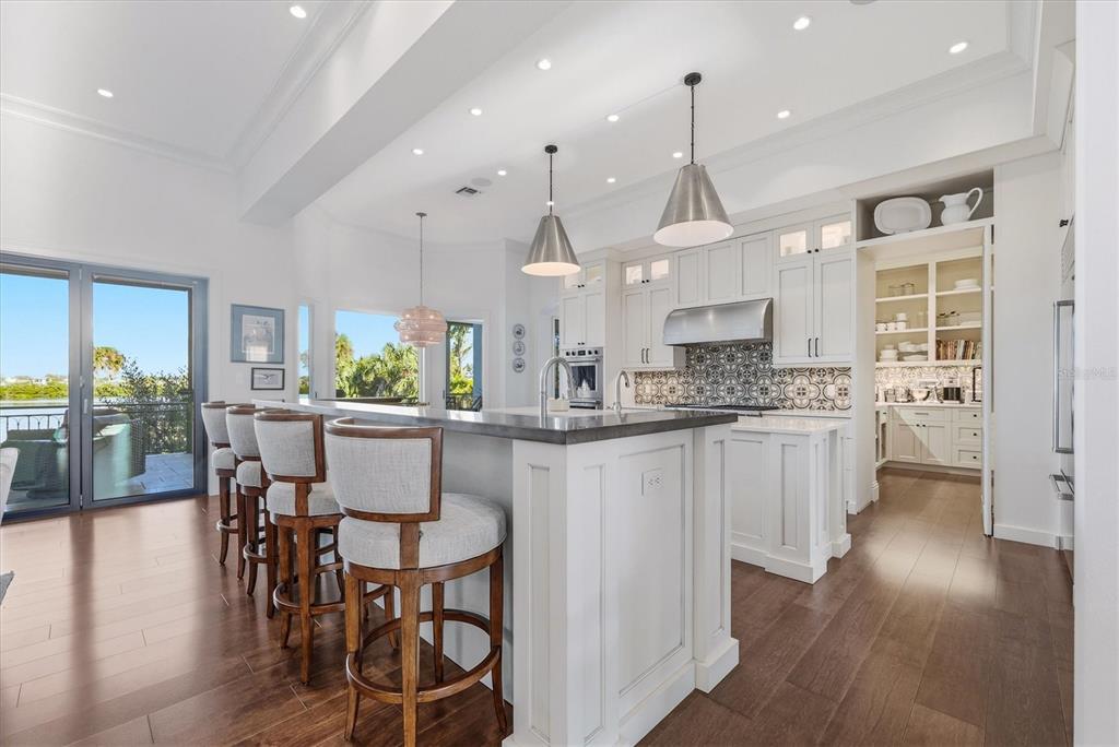3210 Casey Key Road Nokomis, FL 34275 - Photo 28 of 77 a kitchen with stainless steel appliances granite countertop a kitchen island a stove a table and chairs
