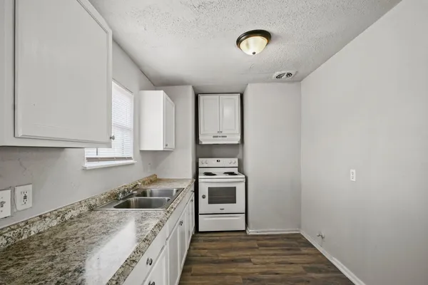 a kitchen with a stove oven and white cabinets