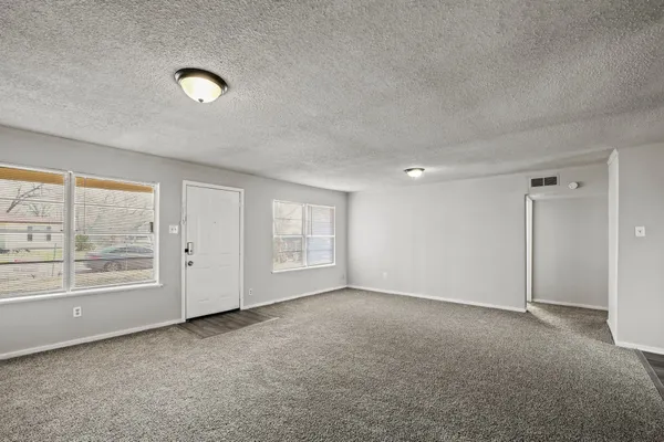 an empty room with windows and closet