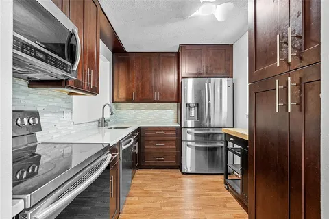 a kitchen with granite countertop a refrigerator and a sink