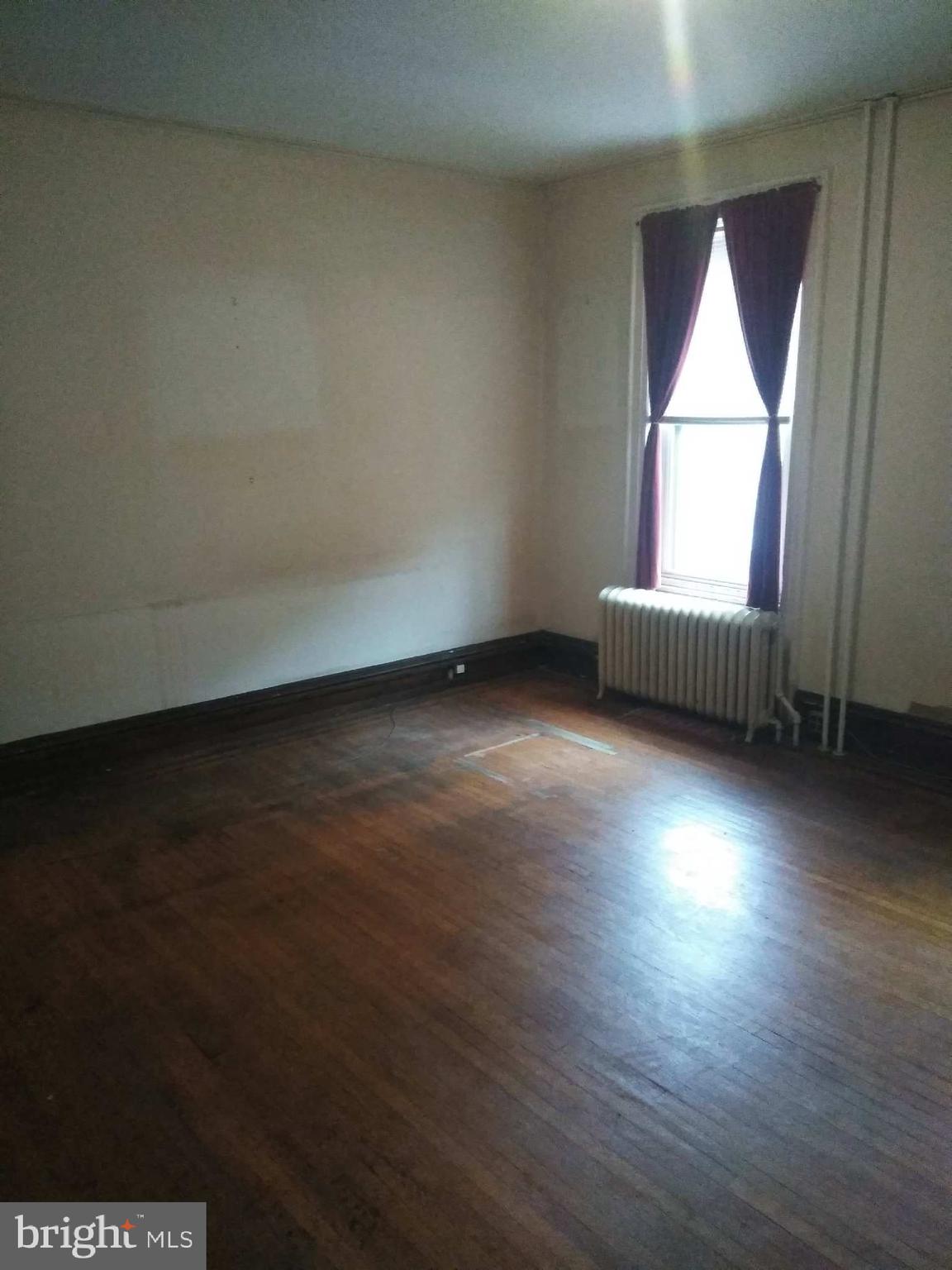 2132 Pine Street Philadelphia, PA 19103 - Photo 4 of 4 an empty room with wooden floor and windows