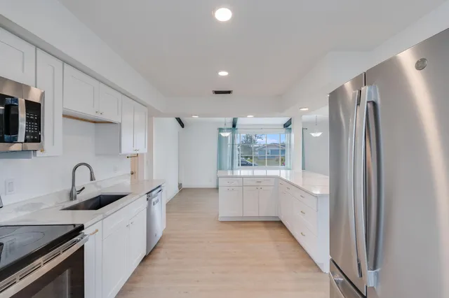 a kitchen with white cabinets and a sink