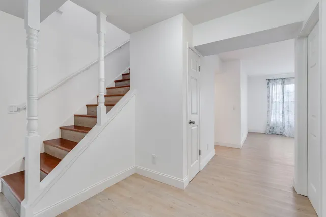 a view of an entryway with wooden floor and staircase