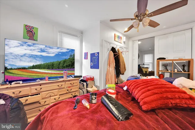 a living room with a bed furniture and a flat screen tv