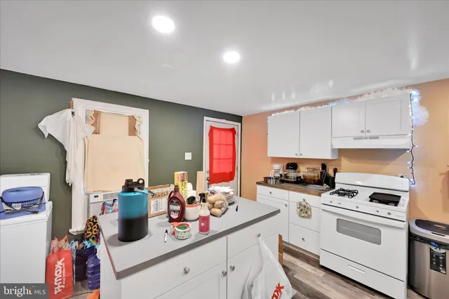 a kitchen with white cabinets and appliances