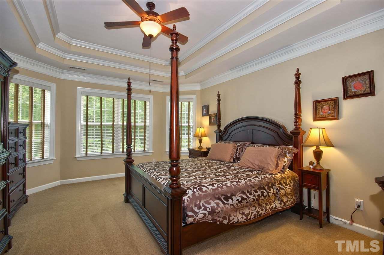 8604 Stonechase Drive Raleigh, NC 27613 - Photo 15 of 25 a bedroom with a large bed and a chandelier