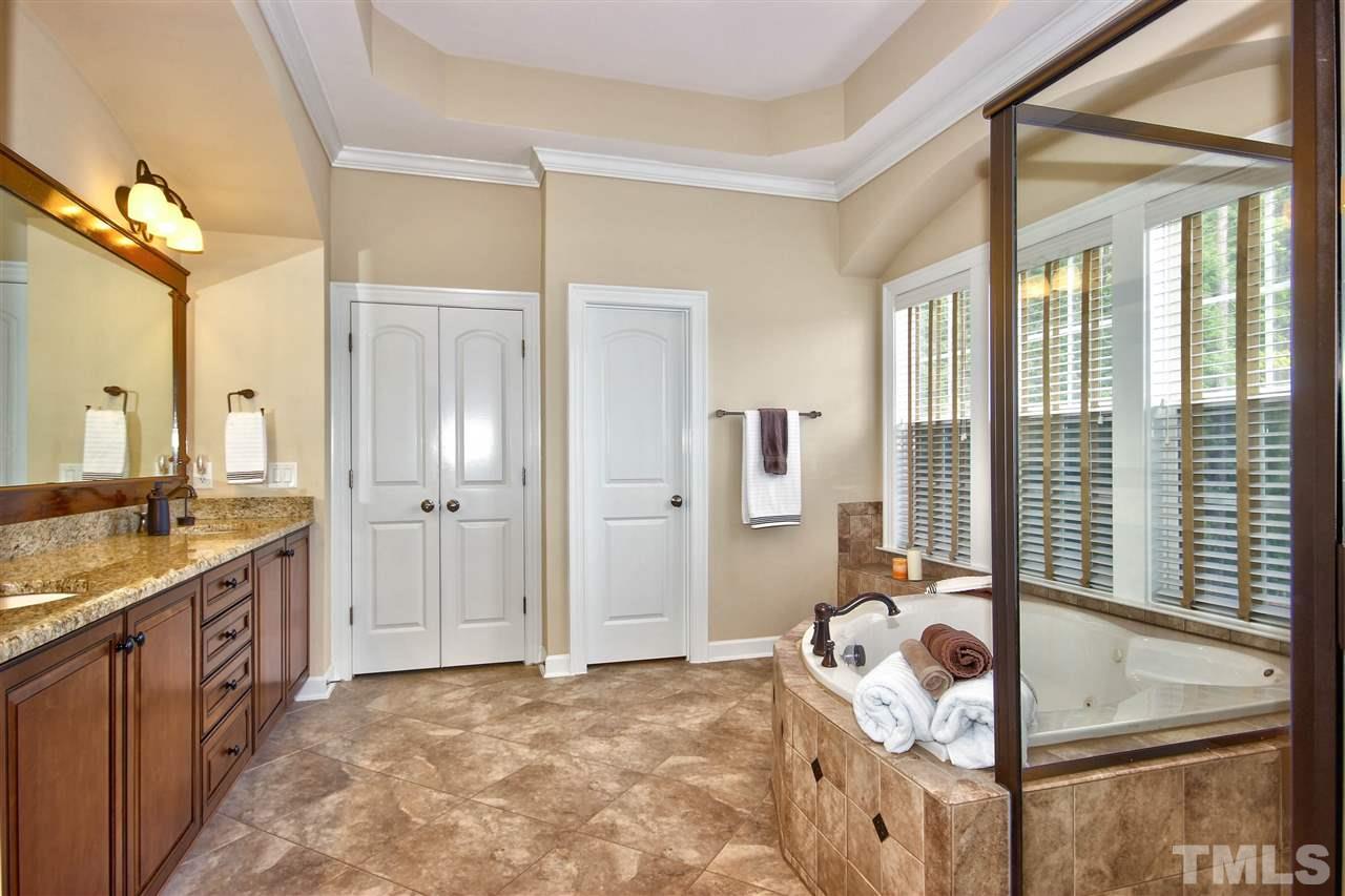 8604 Stonechase Drive Raleigh, NC 27613 - Photo 19 of 25 a bedroom with a bed and a chandelier