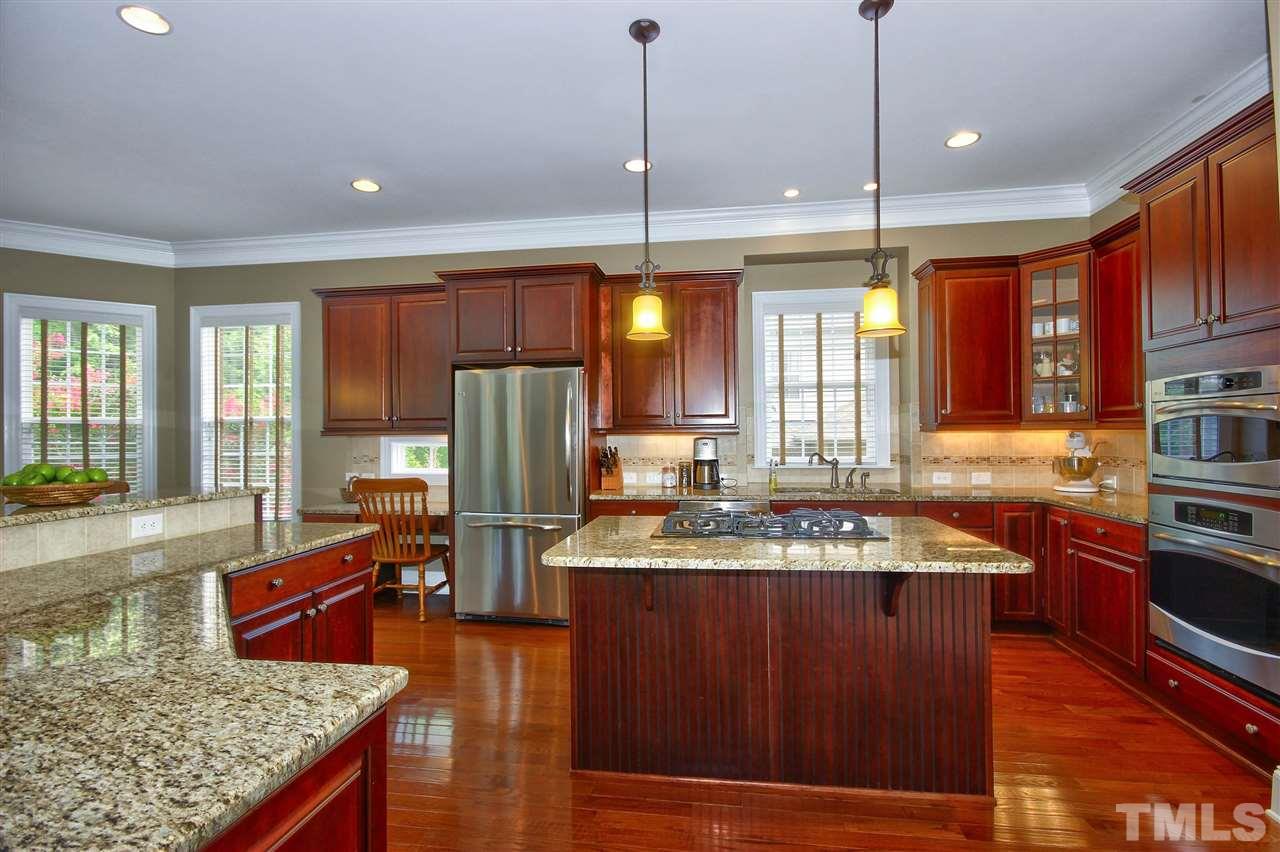 8604 Stonechase Drive Raleigh, NC 27613 - Photo 6 of 25 a kitchen with stainless steel appliances granite countertop a stove refrigerator and cabinets