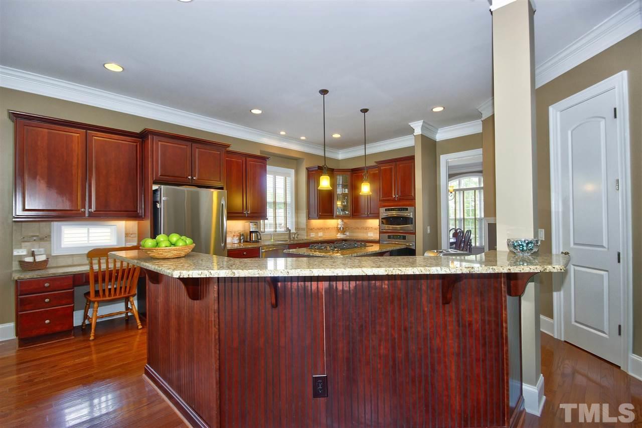 8604 Stonechase Drive Raleigh, NC 27613 - Photo 7 of 25 a kitchen with stainless steel appliances granite countertop a sink a stove and a wooden floors