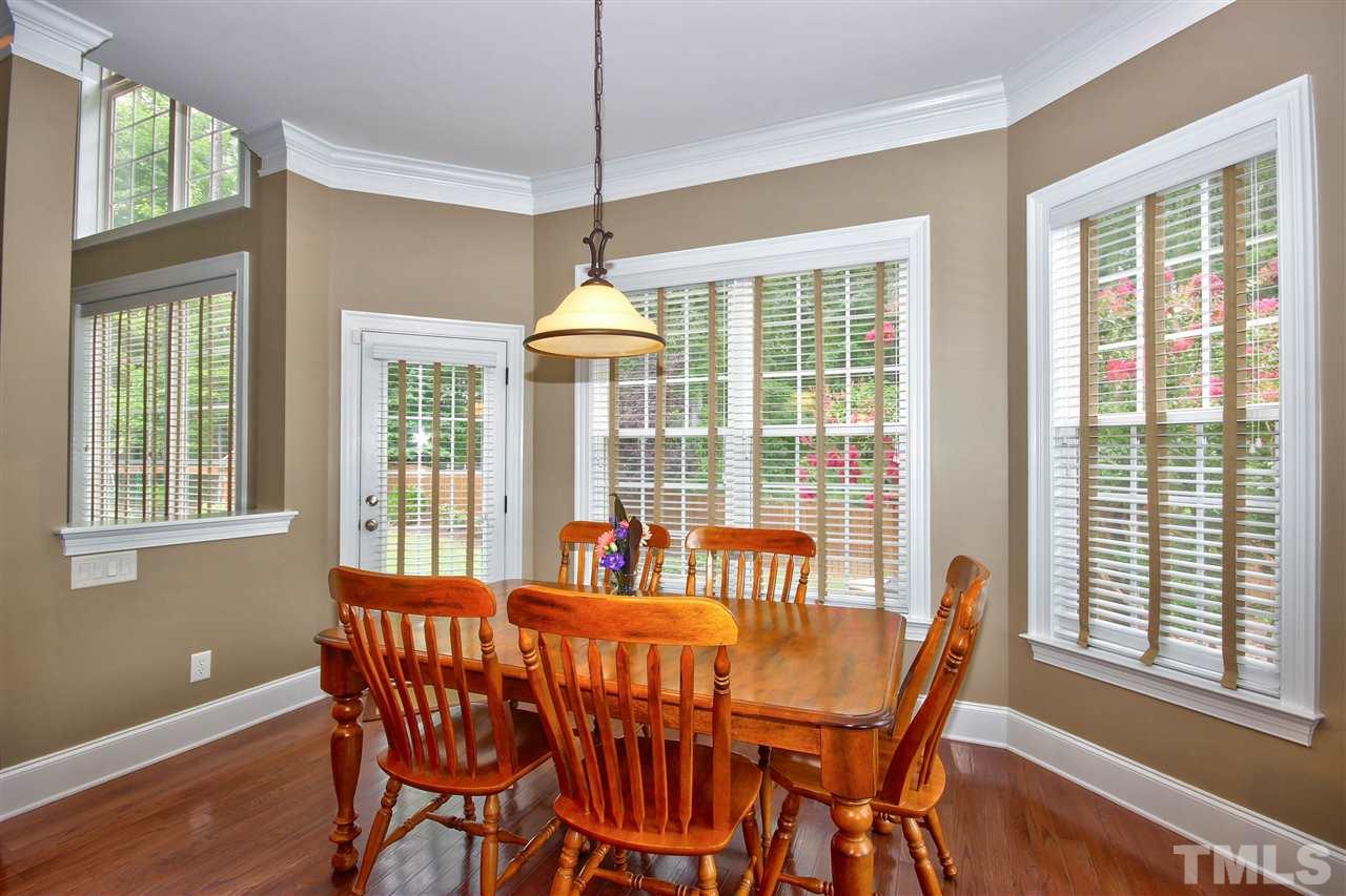 8604 Stonechase Drive Raleigh, NC 27613 - Photo 10 of 25 a view of a dining room with furniture large windows and wooden floor