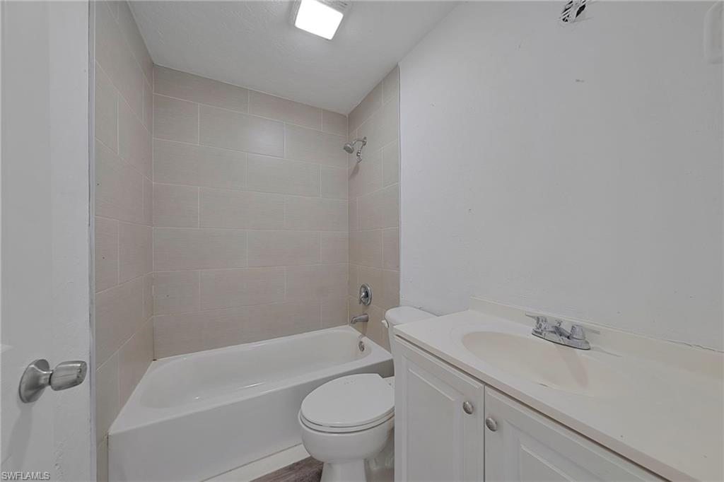 19133 Tangerine Road Fort Myers, FL 33967 - Photo 14 of 17 Full bathroom featuring toilet, vanity, and tiled shower / bath