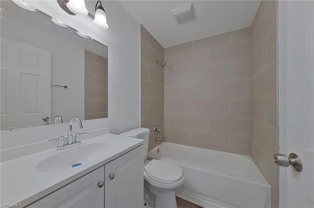 19133 Tangerine Road Fort Myers, FL 33967 - Photo 5 of 17 Full bathroom with tiled shower / bath combo, toilet, and vanity