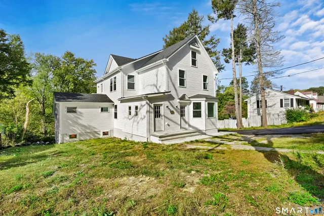 a view of a house with yard and sitting area