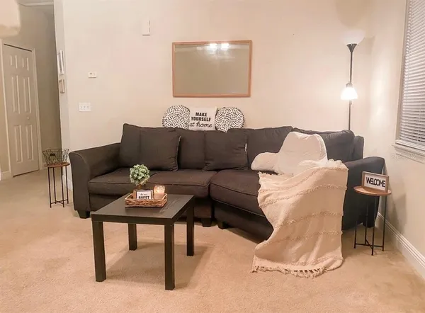 a living room with furniture and a lamp