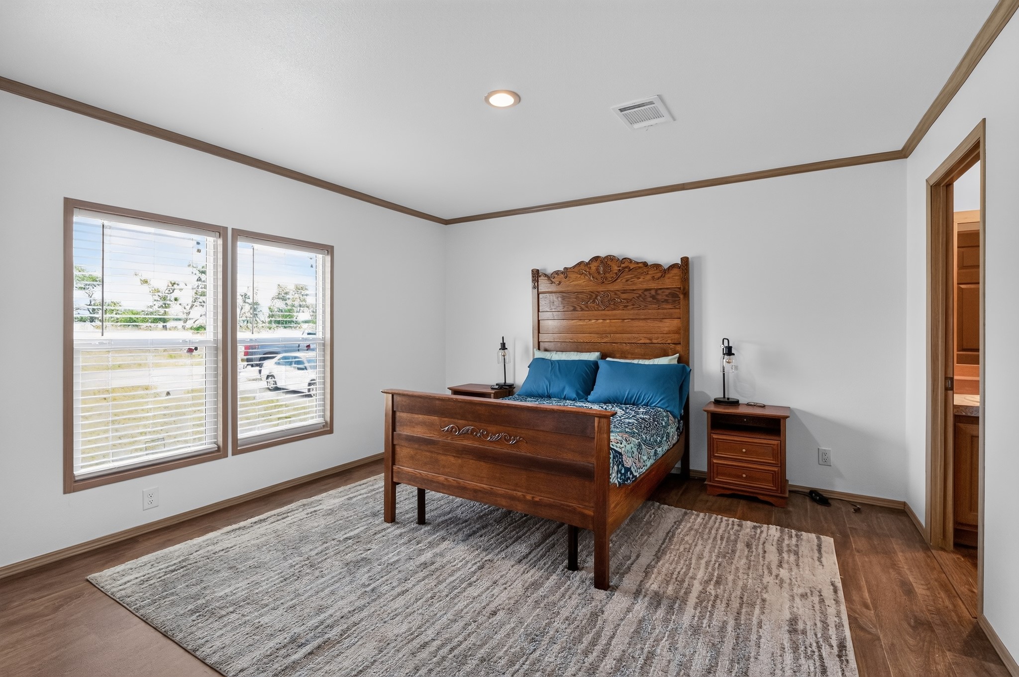 1134 Switchgrass Road Salado, TX 76571 - Photo 18 of 28 Hardwood-style flooring and crown molding define this well-lit bedroom space.