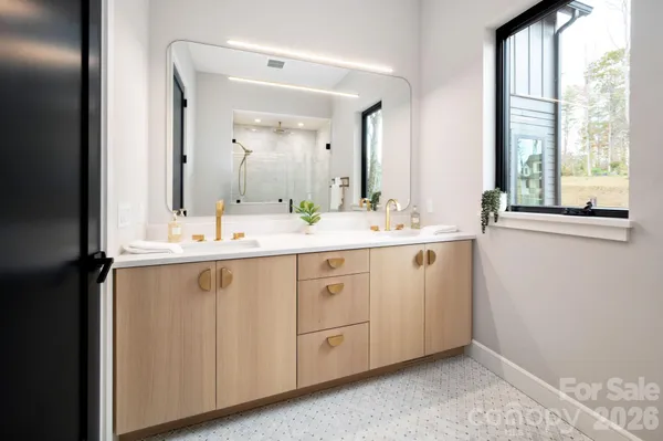 a spacious bathroom with a double vanity sink and a mirror