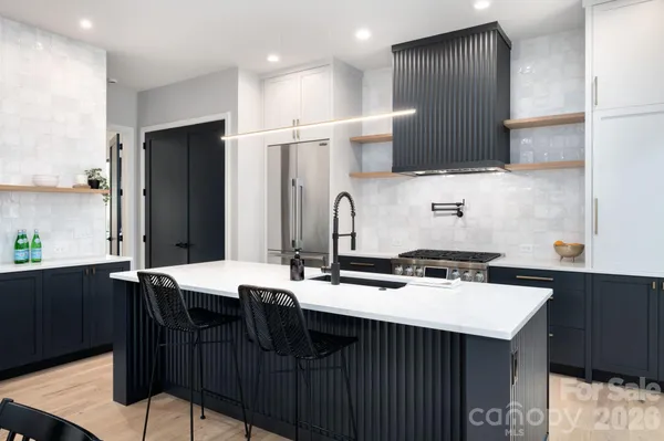 a kitchen with stainless steel appliances a sink a stove a refrigerator and cabinets