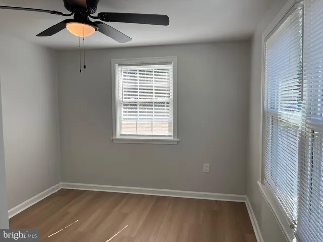 an empty room with window and fan
